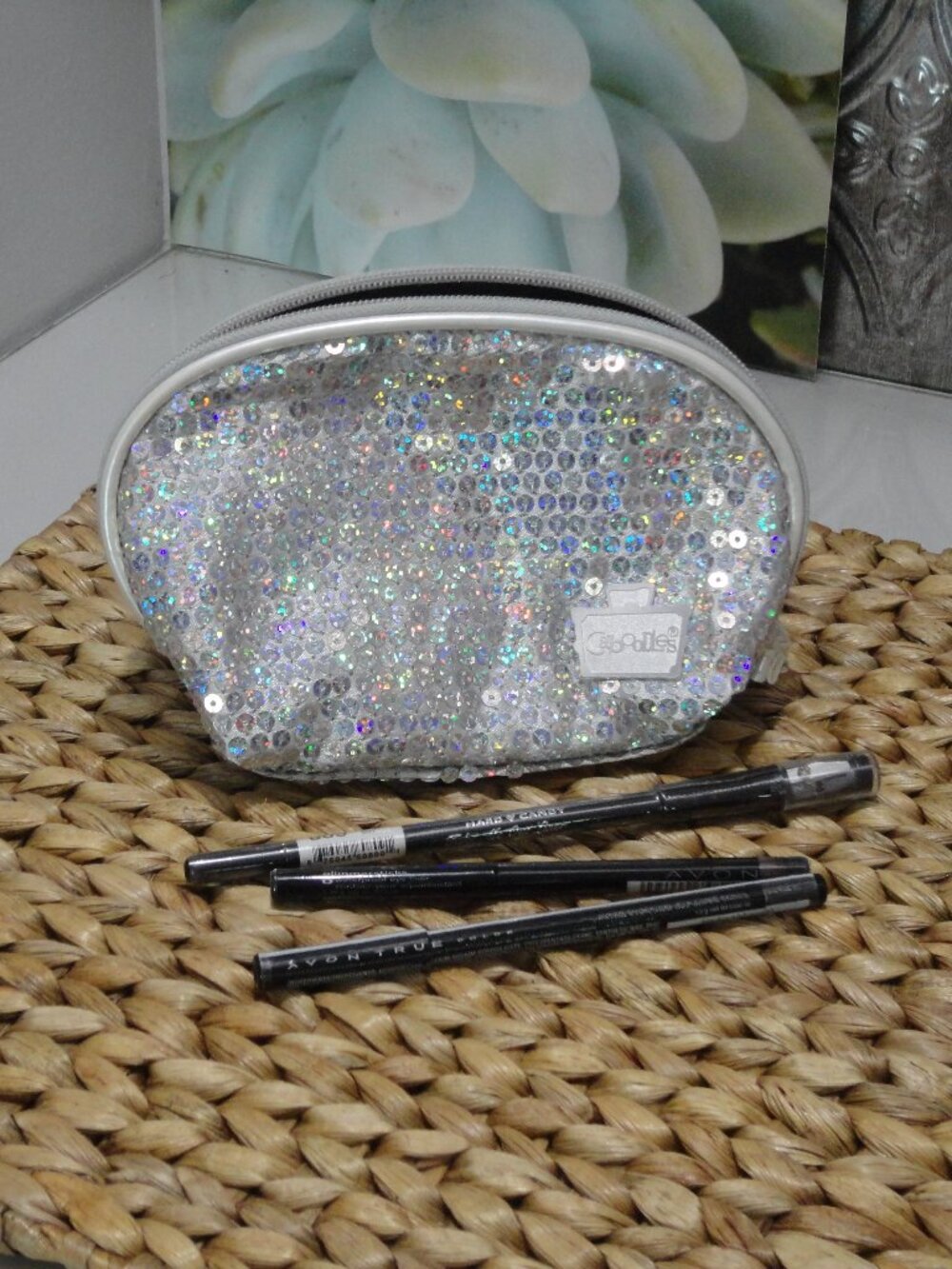 Three eyeliners and a Caboodles makeup bag.